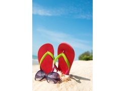 沙滩上的拖鞋与太阳镜