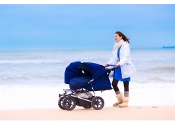 沙滩上推着婴儿车的美女